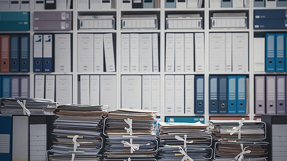 Öffentlicher Dienst: Beschäftigte fühlen sich von Bürokratie ausgebremst Das Foto zeigt eine Wand voll mit Aktenordnern.
