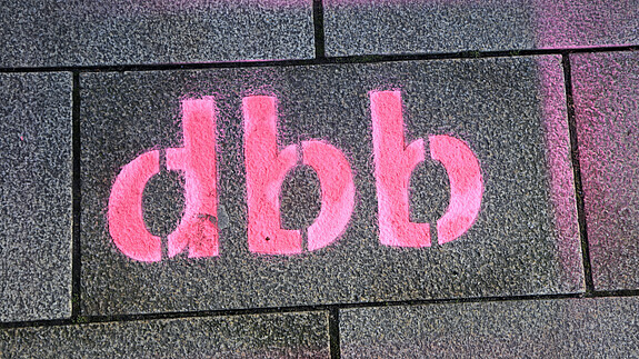 dbb-Logo - Symbolbild Das Foto zeigt das dbb-Logo. Es wurde auf Pflastersteinen auf den Boden gesprayt.