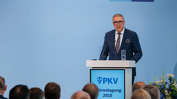 Fotos der PKV Jahrestagung 2025 am 05.06.2025 in Berlin Ein Mann in Anzug steht hinter einem Rednerpult und spricht in ein Mikrofon