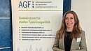 Eine Frau steht vor einem bunten Aufsteller
