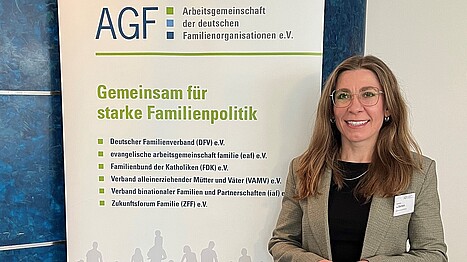 Eine Frau steht vor einem bunten Aufsteller