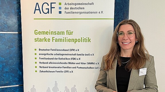 Eine Frau steht vor einem bunten Aufsteller