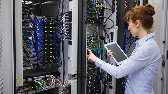 Investitionen in Technik und Personal Frau im Serverraum