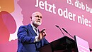 Ein Mann steht hinter einem Rednerpult und spricht in das Mikrofon