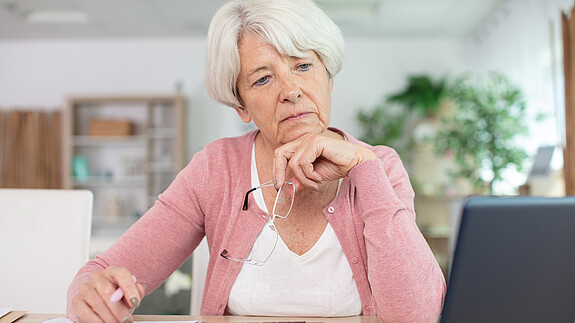 Foto zum Thema "Aktivrente und Einbeziehung von Beamten": Zu sehen ist eine Seniorin, die am Rechner sitzt und arbeitet.