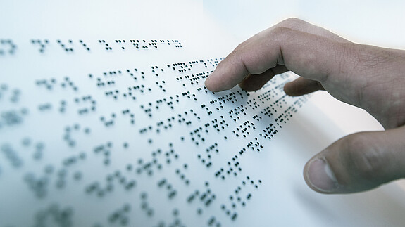Hand auf Blindenschrift