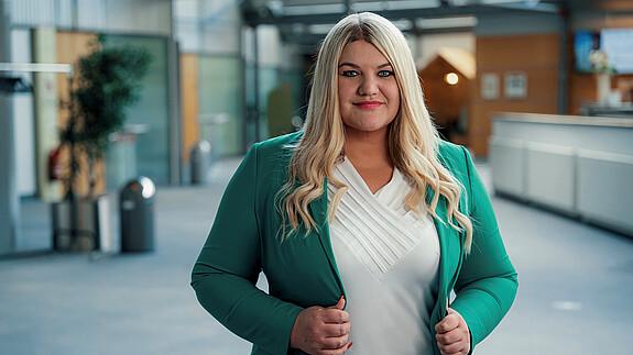 Foto einer Frau mit blonden Haaren und grüner Jacke
